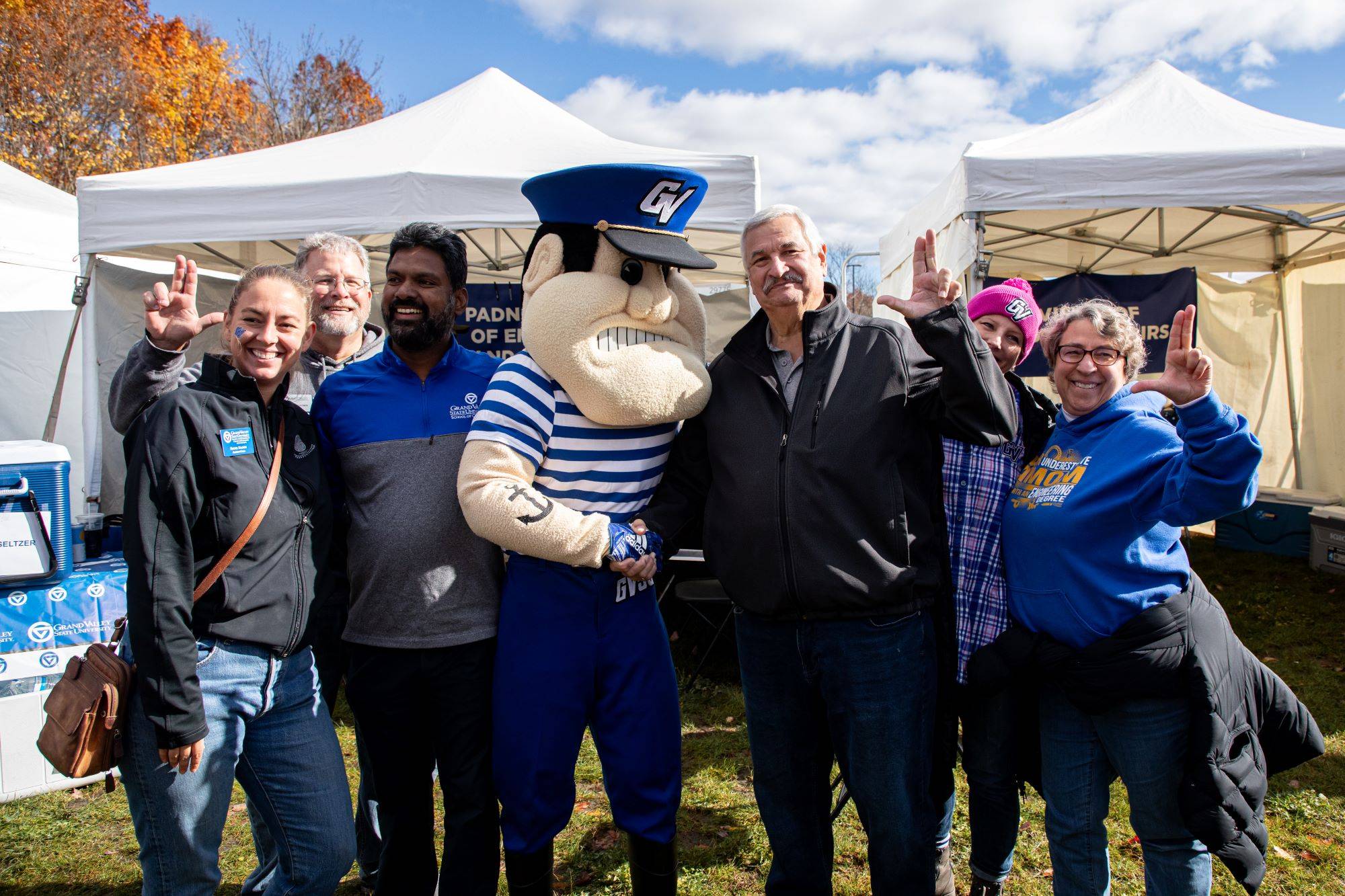 A group of family and friends pose together at the Homecoming Tailgate